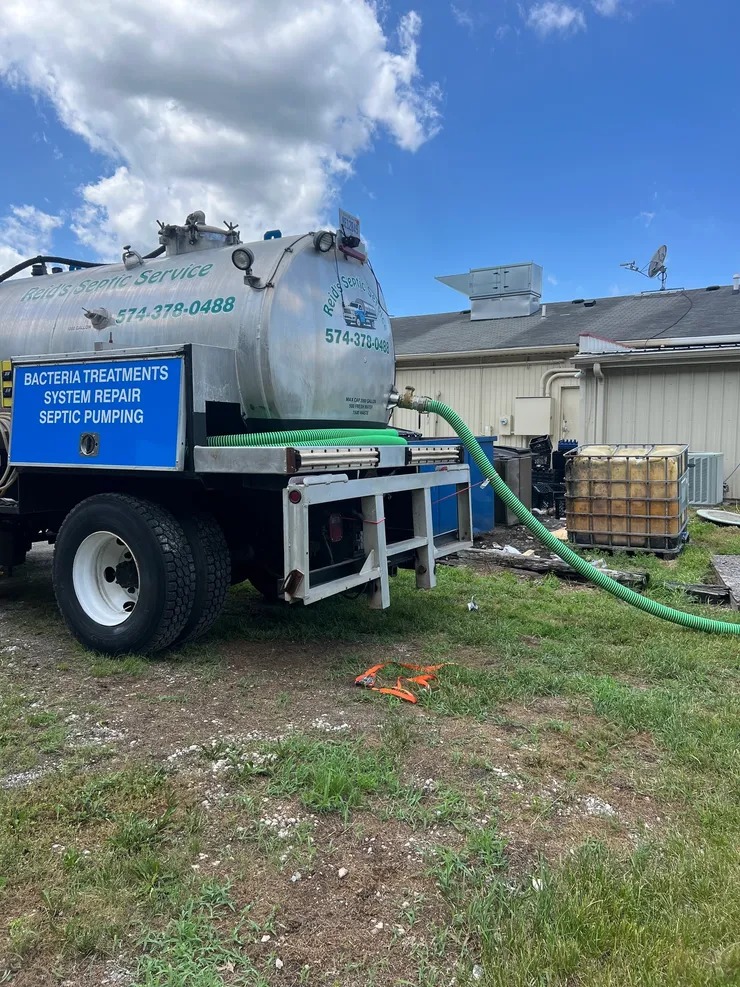 Technician pumping out a residential septic tank during a scheduled service call